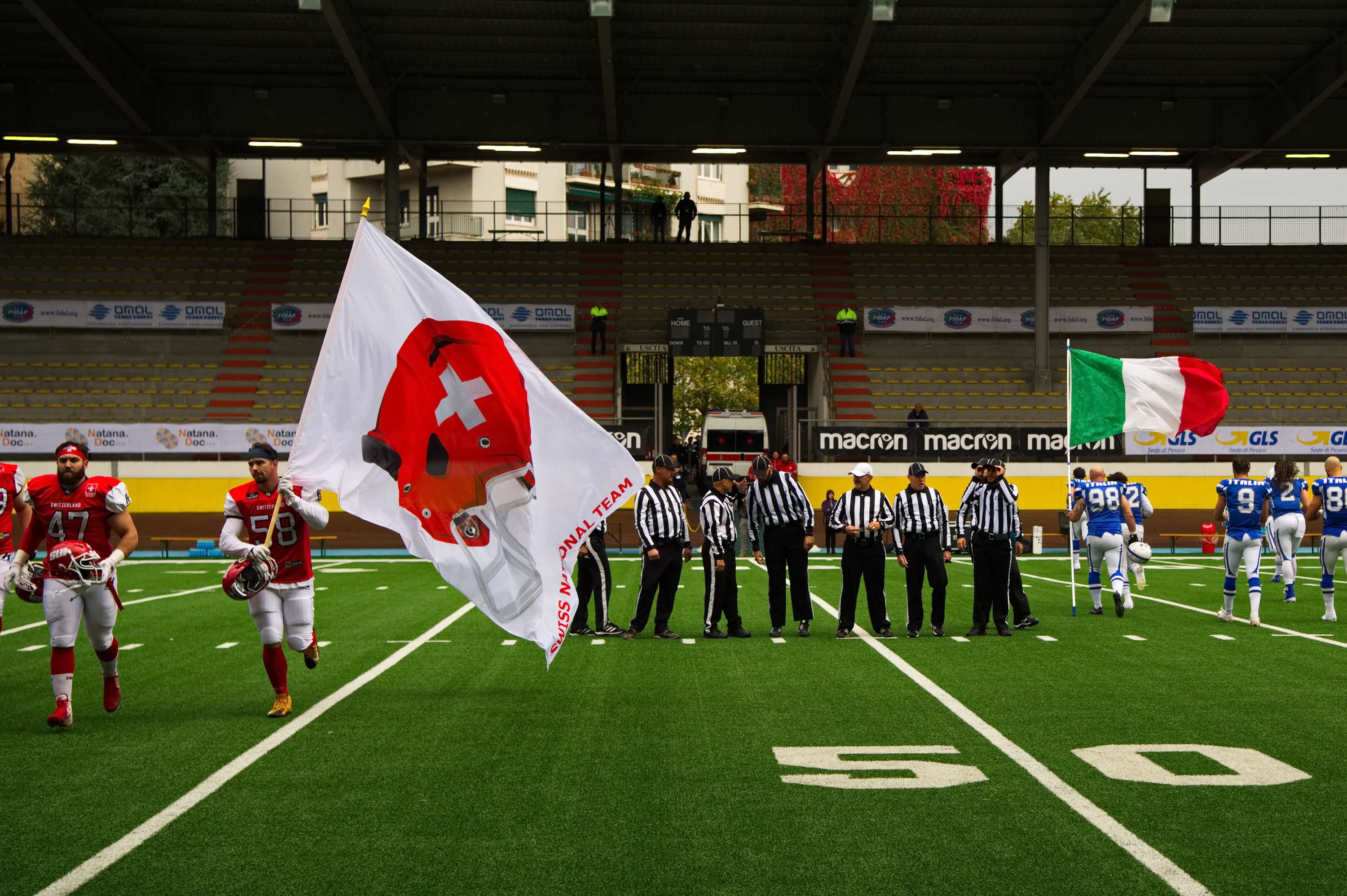 Football Player with there National flag before Game. Refrees waiting in the middle of the Field.